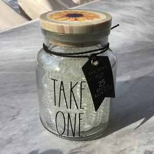 Rae Dunn glass apothecary jar with 25 spiral hair ties. Sunflower on lid.